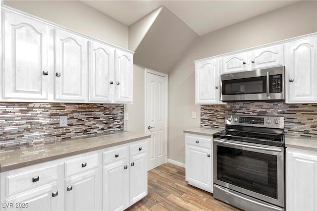 251 Big Horn Dr, Boulder City, NV 89005 - kitchen with stainless steel appliances, white cabinetry, backsplash, and lofted ceiling