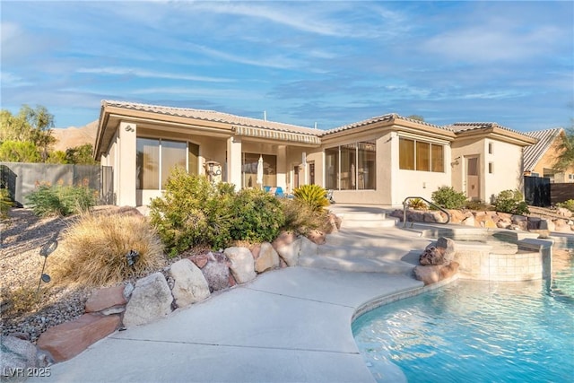 1239 N Hollywood Blvd, Las Vegas, NV 89110 - rear view of property with stucco siding, a tiled roof, and a pool with connected hot tub