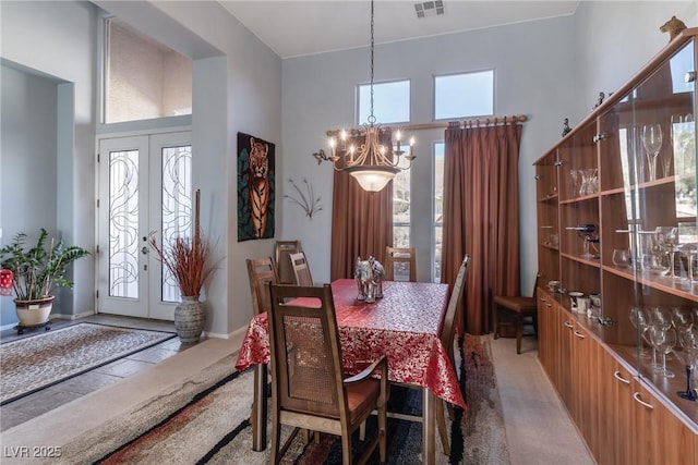 1239 N Hollywood Blvd, Las Vegas, NV 89110 - dining area featuring a towering ceiling, a chandelier, french doors, and light colored carpet
