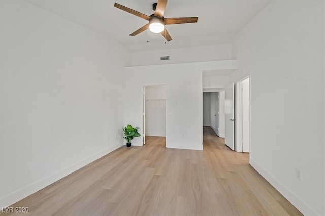 8924 Signal Terrace Dr, Las Vegas, NV 89134 - unfurnished bedroom with light wood-style flooring, a walk in closet, a closet, and a ceiling fan