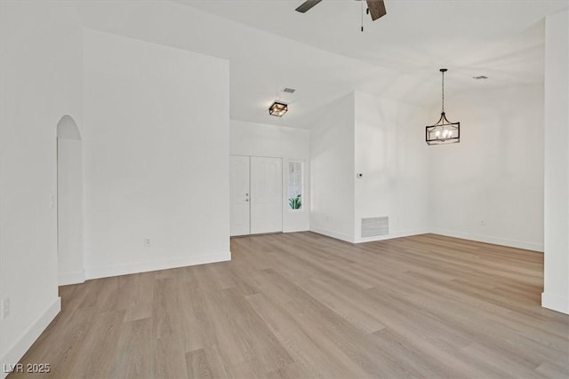 8924 Signal Terrace Dr, Las Vegas, NV 89134 - spare room with light wood-type flooring, ceiling fan, arched walkways, a chandelier, and vaulted ceiling