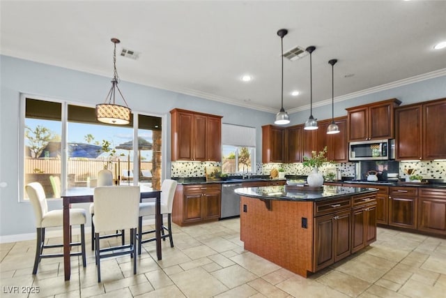 8209 Chapelle Ct, Las Vegas, NV 89131 - kitchen with stainless steel appliances, a center island, backsplash, hanging light fixtures, and crown molding