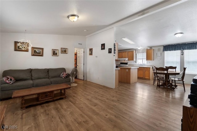 6337 W Cactus Ave, Las Vegas, NV 89141 - living area with wood finished floors, a chandelier, and vaulted ceiling