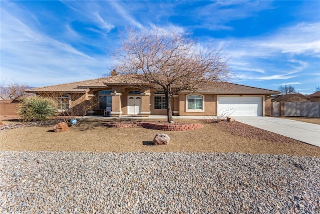 6781 Southgate St, Pahrump, NV 89061 - view of front facade featuring concrete driveway, stucco siding, an attached garage, and a tiled roof