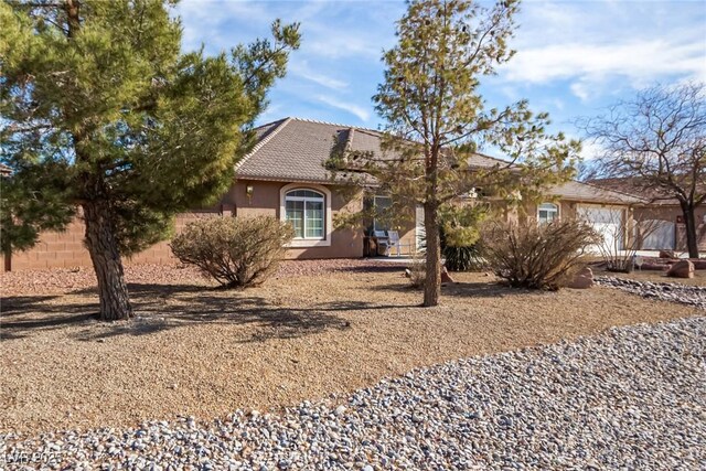 6781 Southgate St, Pahrump, NV 89061 - view of property hidden behind natural elements with stucco siding and a tile roof