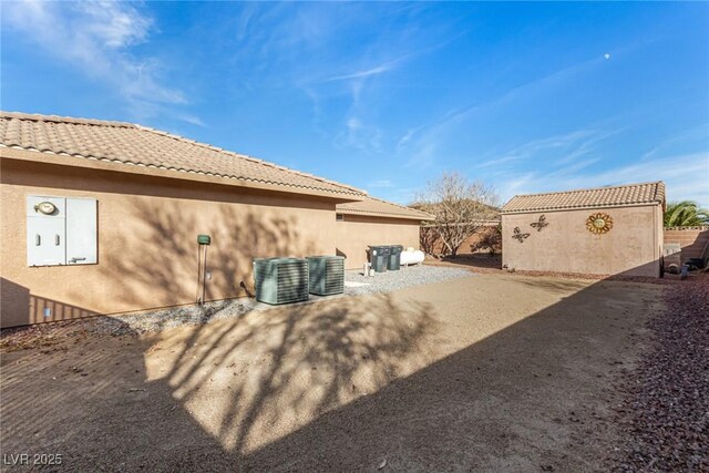 6781 Southgate St, Pahrump, NV 89061 - rear view of property featuring stucco siding and a tiled roof