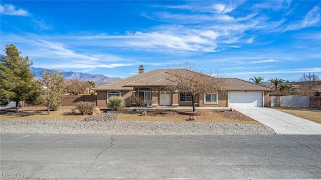 6781 Southgate St, Pahrump, NV 89061 - single story home featuring stucco siding, a tiled roof, concrete driveway, a chimney, and an attached garage