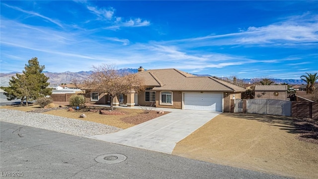 6781 Southgate St, Pahrump, NV 89061 - ranch-style house featuring a gate, a garage, driveway, a mountain view, and stucco siding