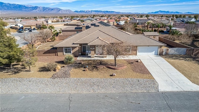6781 Southgate St, Pahrump, NV 89061 - ranch-style house with a tiled roof, a garage, a residential view, and concrete driveway