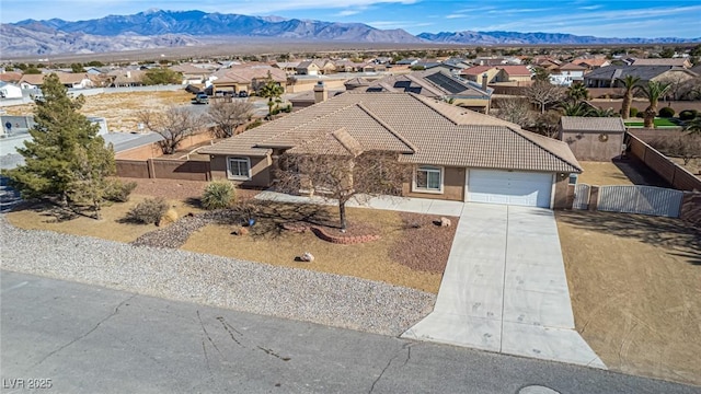6781 Southgate St, Pahrump, NV 89061 - view of front facade featuring a tiled roof, a residential view, a garage, driveway, and stucco siding