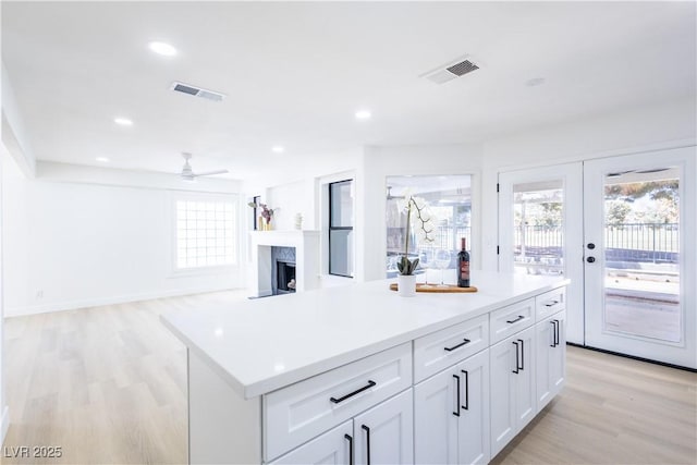5264 Silverheart Ave, Las Vegas, NV 89142 - kitchen featuring a ceiling fan, light wood-style floors, plenty of natural light, white cabinets, and recessed lighting