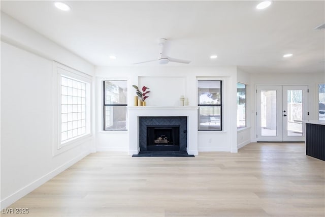5264 Silverheart Ave, Las Vegas, NV 89142 - unfurnished living room featuring light wood finished floors, french doors, recessed lighting, a fireplace with raised hearth, and a ceiling fan