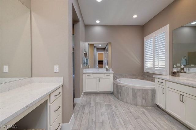 10349 Bressana Dr, Las Vegas, NV 89135 - bathroom with two vanities, a garden tub, recessed lighting, and wood finished floors