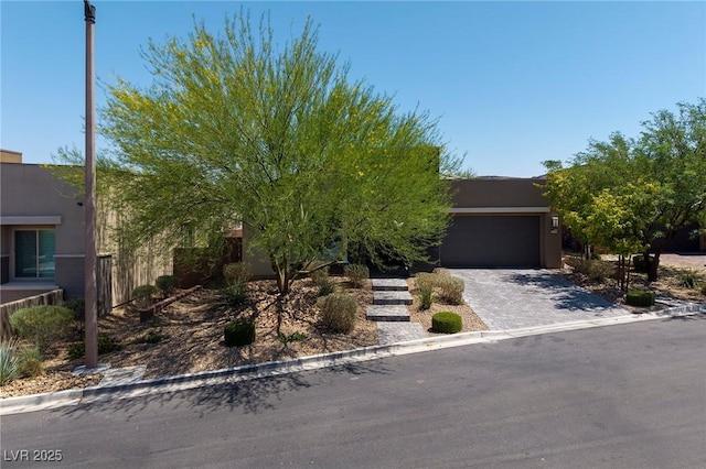 10349 Bressana Dr, Las Vegas, NV 89135 - view of front facade featuring stucco siding, decorative driveway, and an attached garage