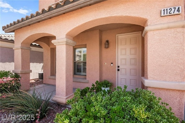11274 Civita St, Las Vegas, NV 89141 - view of exterior entry with stucco siding, covered porch, and a tiled roof