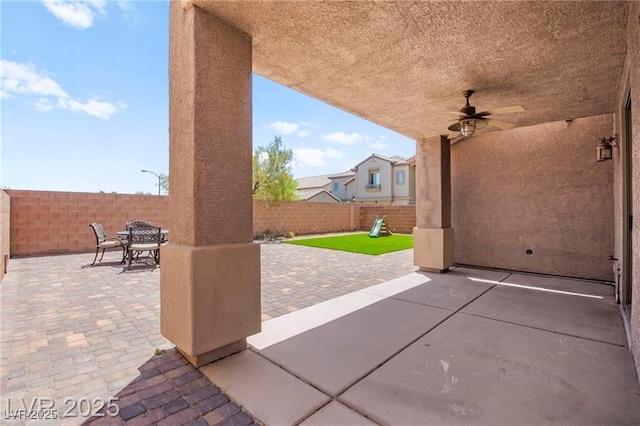 11274 Civita St, Las Vegas, NV 89141 - fenced backyard with a patio area, outdoor dining space, a playground, and a ceiling fan