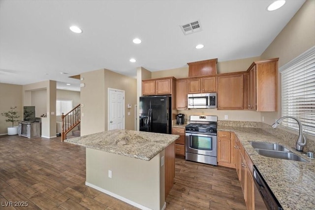 7028 Weavers Pl, North Las Vegas, NV 89084 - kitchen with stainless steel appliances, a kitchen island, dark wood-style floors, light stone countertops, and recessed lighting