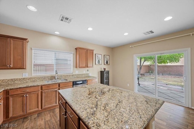 7028 Weavers Pl, North Las Vegas, NV 89084 - kitchen with dishwasher, wood finished floors, a center island, light stone counters, and recessed lighting