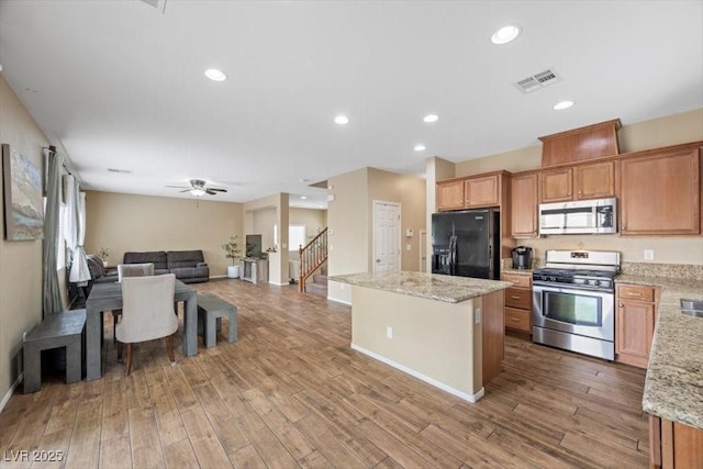7028 Weavers Pl, North Las Vegas, NV 89084 - kitchen featuring appliances with stainless steel finishes, a kitchen island, open floor plan, light wood-type flooring, and recessed lighting