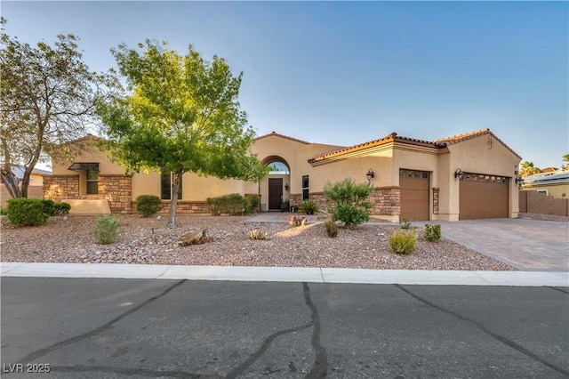 7670 Frittata Ave, Las Vegas, NV 89113 - mediterranean / spanish-style home with stucco siding, stone siding, an attached garage, driveway, and a tiled roof