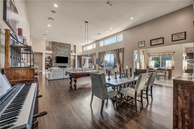 7670 Frittata Ave, Las Vegas, NV 89113 - dining area featuring healthy amount of natural light, recessed lighting, wood finished floors, a high ceiling, and a stone fireplace