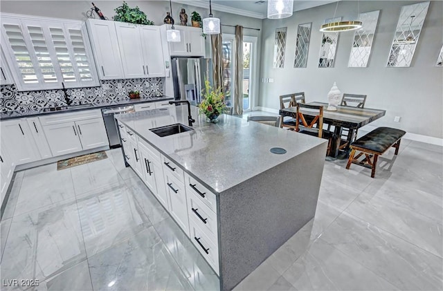 2891 S Rainbow Ave, Pahrump, NV 89048 - kitchen with stainless steel appliances, a center island with sink, decorative light fixtures, white cabinets, and crown molding