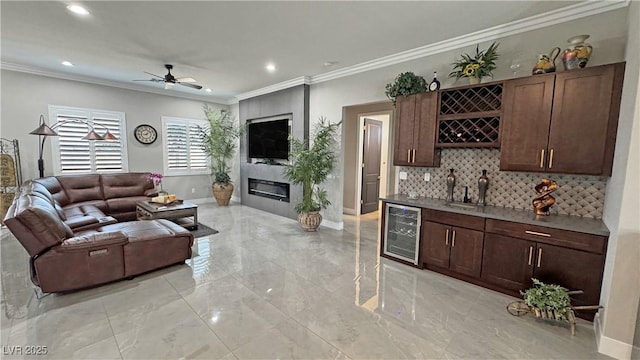 2891 S Rainbow Ave, Pahrump, NV 89048 - living room featuring beverage cooler, bar with sink, light marble finish floors, ornamental molding, and recessed lighting