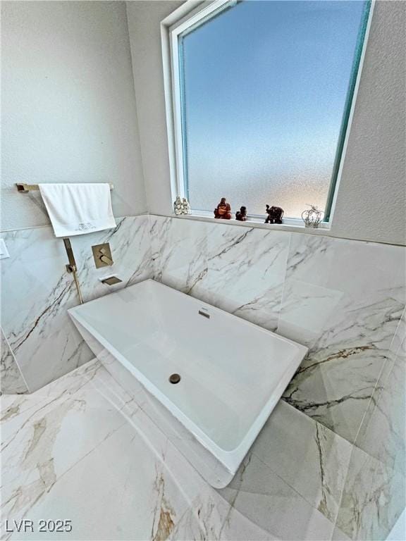 2891 S Rainbow Ave, Pahrump, NV 89048 - bathroom with a freestanding bath, tile walls, and wainscoting