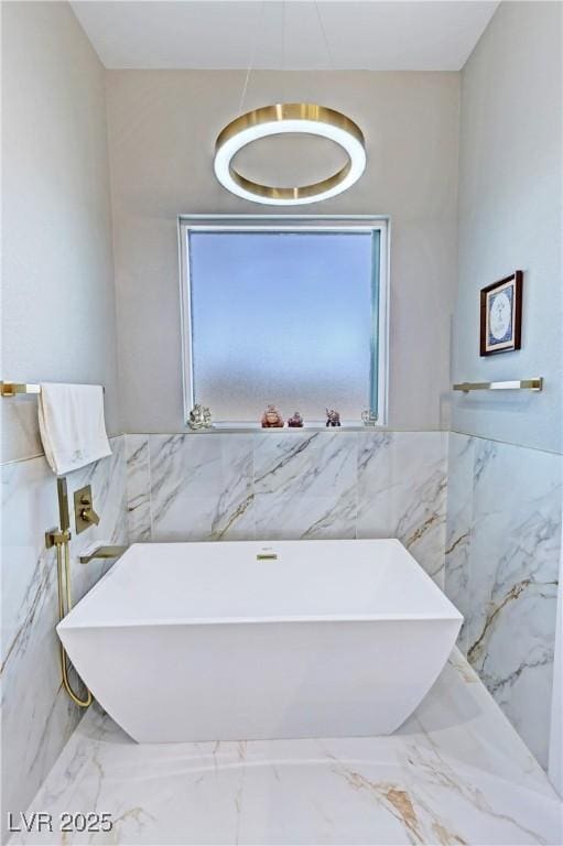 2891 S Rainbow Ave, Pahrump, NV 89048 - full bath featuring tile walls, a freestanding bath, and marble tiled floors
