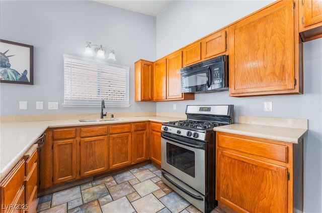 1012 Greystone Dr, Las Vegas, NV 89108 - kitchen with black microwave, stainless steel range with gas stovetop, light countertops, stone finish flooring, and brown cabinetry