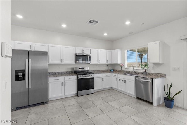 9054 Tangerine Tree Ct, Las Vegas, NV 89113 - kitchen with appliances with stainless steel finishes, white cabinetry, stone countertops, recessed lighting, and light tile patterned floors
