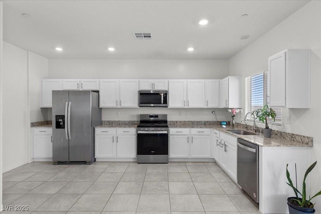 9054 Tangerine Tree Ct, Las Vegas, NV 89113 - kitchen featuring appliances with stainless steel finishes, light stone countertops, white cabinetry, and recessed lighting