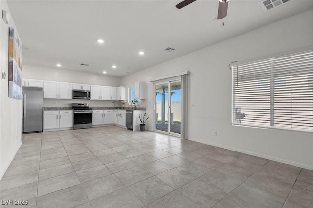 9054 Tangerine Tree Ct, Las Vegas, NV 89113 - kitchen with stainless steel appliances, recessed lighting, white cabinets, ceiling fan, and light tile patterned floors