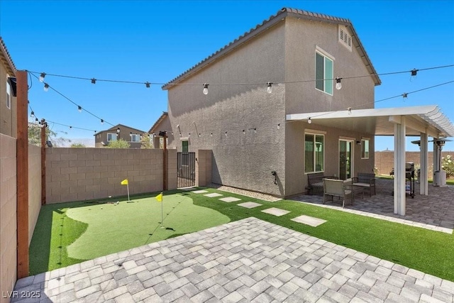 9054 Tangerine Tree Ct, Las Vegas, NV 89113 - back of property with a putting green, a patio area, a fenced backyard, stucco siding, and a tiled roof