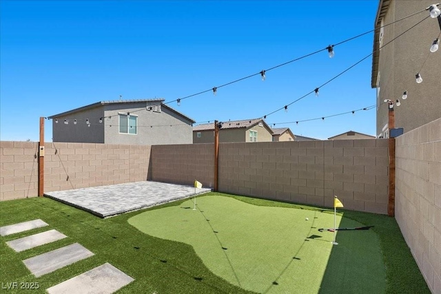 9054 Tangerine Tree Ct, Las Vegas, NV 89113 - fenced backyard featuring an area to practice putting and a patio area