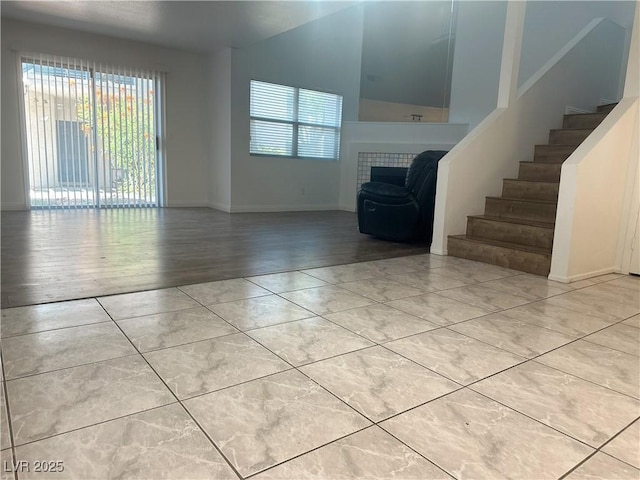 6250 W Flamingo Rd Unit 88, Las Vegas, NV 89103 - unfurnished living room with plenty of natural light, stairs, and light tile patterned flooring