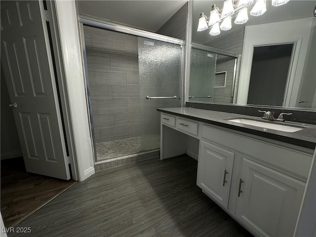 6250 W Flamingo Rd Unit 88, Las Vegas, NV 89103 - bathroom featuring vanity, a shower stall, wood finished floors, and a chandelier