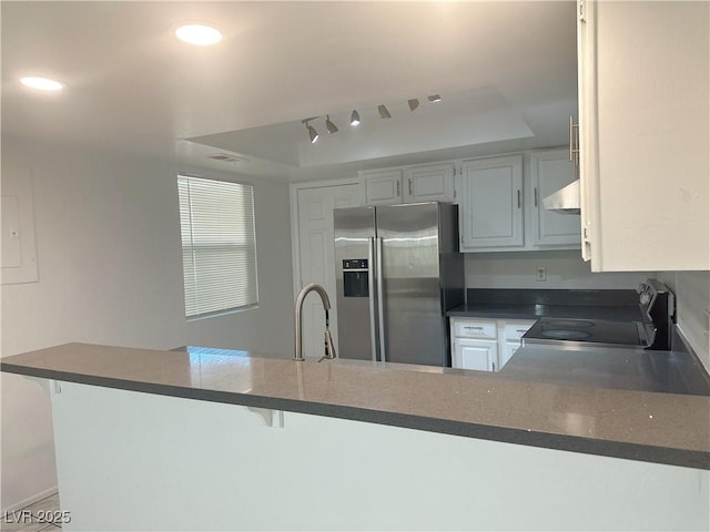 6250 W Flamingo Rd Unit 88, Las Vegas, NV 89103 - kitchen featuring stainless steel fridge, range, a tray ceiling, dark countertops, and a peninsula
