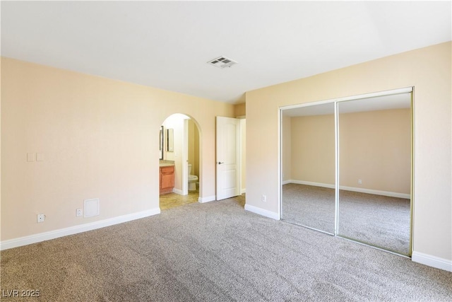 1836 N Decatur Blvd Unit 203, Las Vegas, NV 89108 - unfurnished bedroom with arched walkways, carpet, a closet, and ensuite bathroom