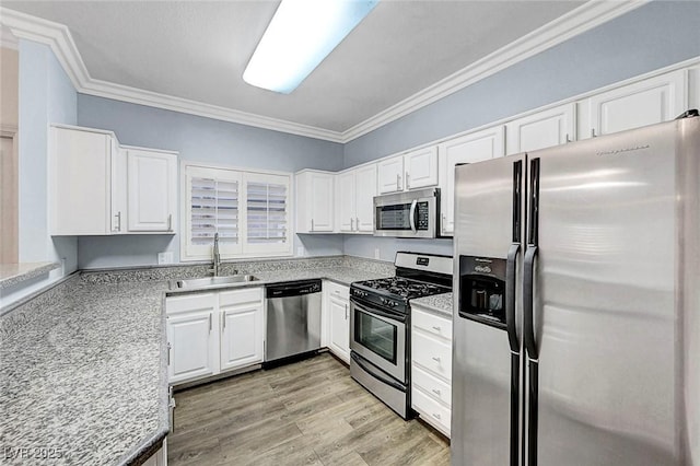 5250 S Rainbow Blvd Unit 1057, Las Vegas, NV 89118 - kitchen featuring appliances with stainless steel finishes, ornamental molding, white cabinetry, and light wood finished floors