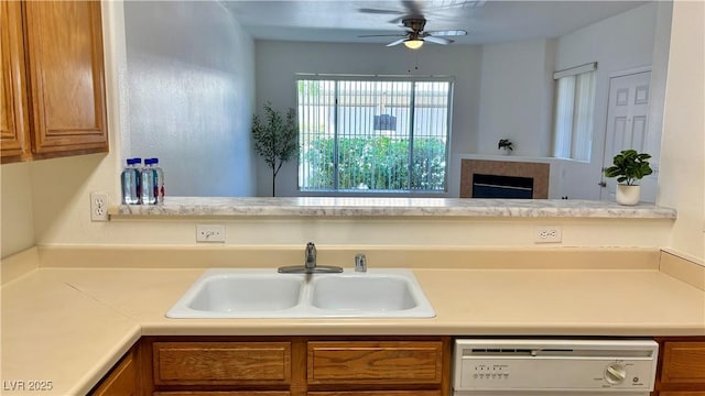 7163 S Durango Dr Unit 113, Las Vegas, NV 89113 - kitchen with dishwasher, brown cabinetry, light countertops, ceiling fan, and a tiled fireplace