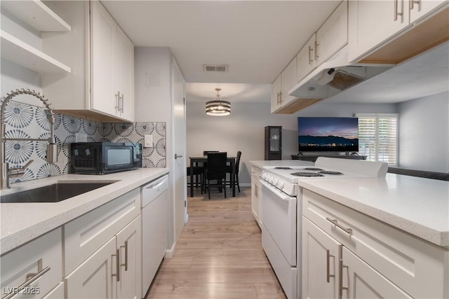 1407 Dorothy Ave Unit 2, Las Vegas, NV 89119 - kitchen featuring white appliances, white cabinets, light wood-style flooring, and backsplash