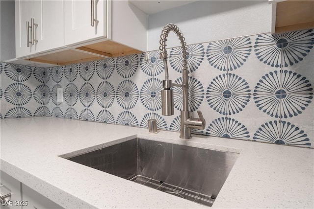 1407 Dorothy Ave Unit 2, Las Vegas, NV 89119 - kitchen view of decorative backsplash, light stone countertops, and white cabinets