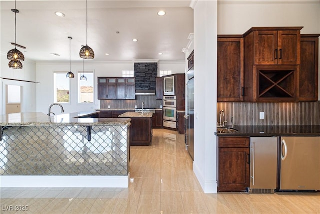 1319 Red Baron Ln, Boulder City, NV 89005 - kitchen featuring an island with sink, appliances with stainless steel finishes, tasteful backsplash, recessed lighting, and light stone countertops
