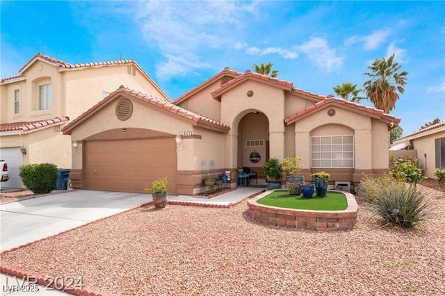 5121 Backwoodsman Ave, Las Vegas, NV 89130 - mediterranean / spanish-style house with stucco siding, driveway, an attached garage, and a tile roof