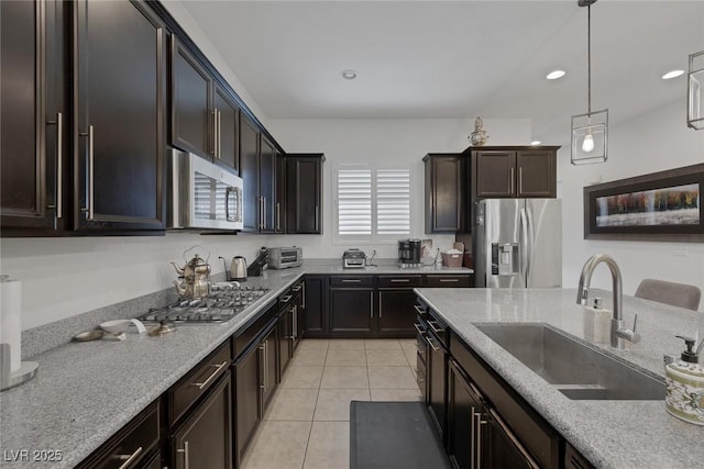 10181 Mount Harlow Ct, Las Vegas, NV 89141 - kitchen with stainless steel appliances, light tile patterned floors, hanging light fixtures, light stone counters, and recessed lighting
