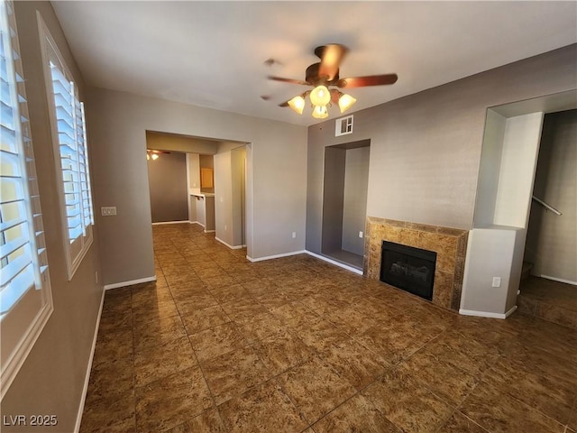 10231 Deerfield Beach Ave Unit 104, Las Vegas, NV 89129 - unfurnished living room featuring ceiling fan, a tiled fireplace, and tile patterned floors