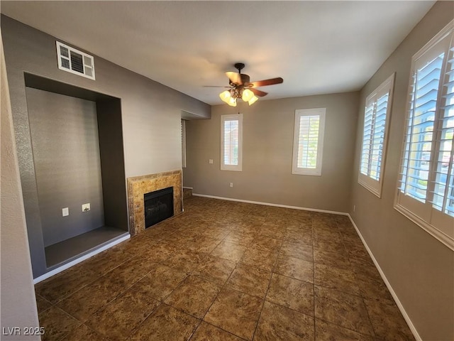 10231 Deerfield Beach Ave Unit 104, Las Vegas, NV 89129 - unfurnished living room featuring a tiled fireplace and a ceiling fan