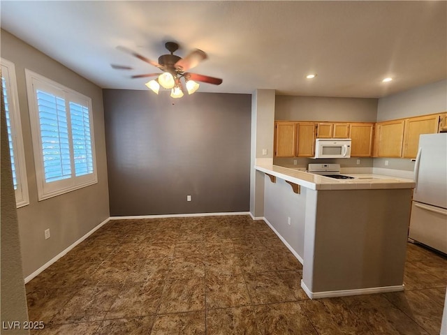 10231 Deerfield Beach Ave Unit 104, Las Vegas, NV 89129 - kitchen with white microwave, freestanding refrigerator, range, a peninsula, and tile countertops