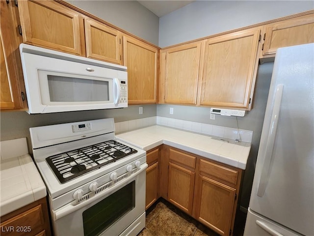 10231 Deerfield Beach Ave Unit 104, Las Vegas, NV 89129 - kitchen with white appliances, tile counters, and light brown cabinets